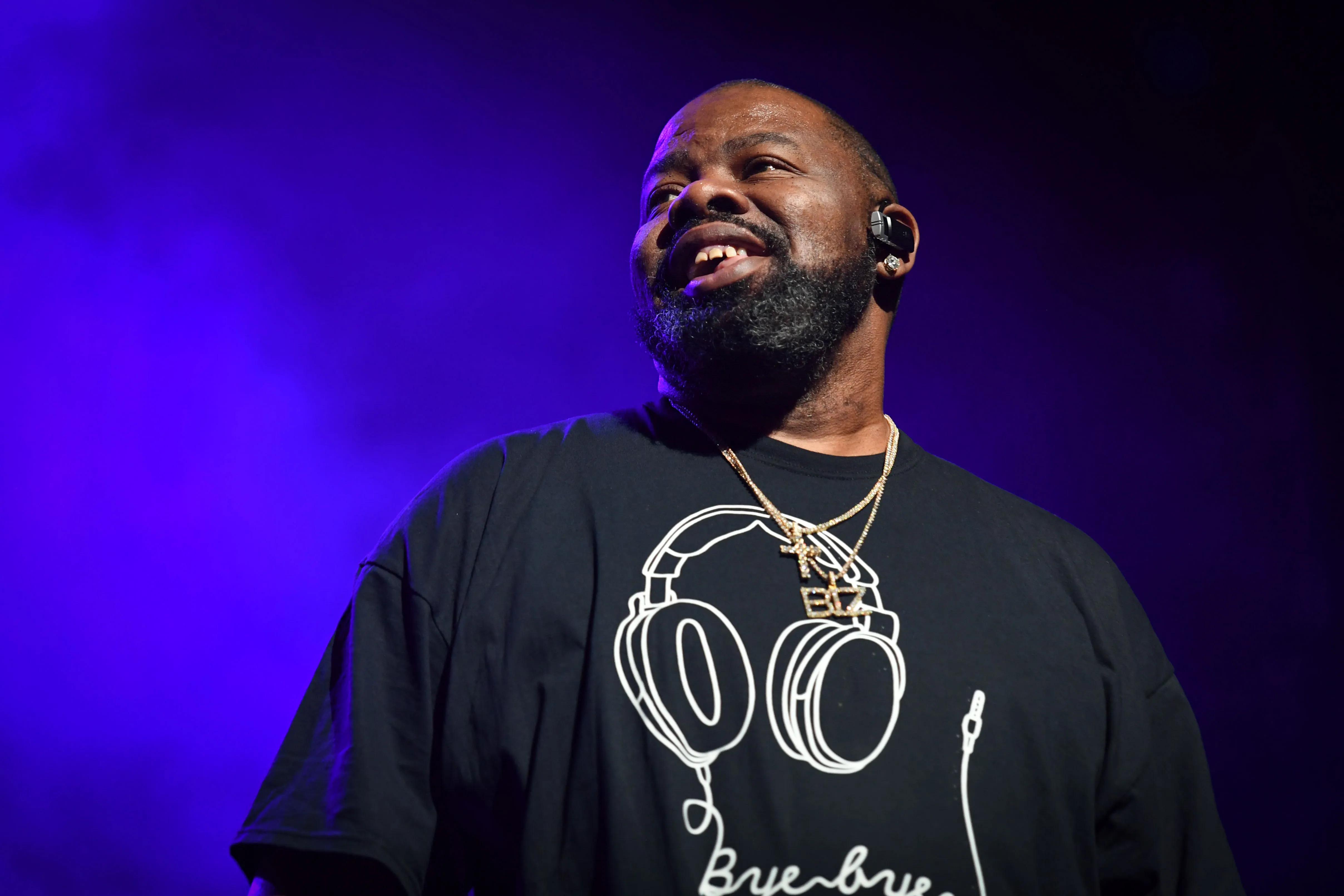 Biz Markie smiling on stage with purple lighting